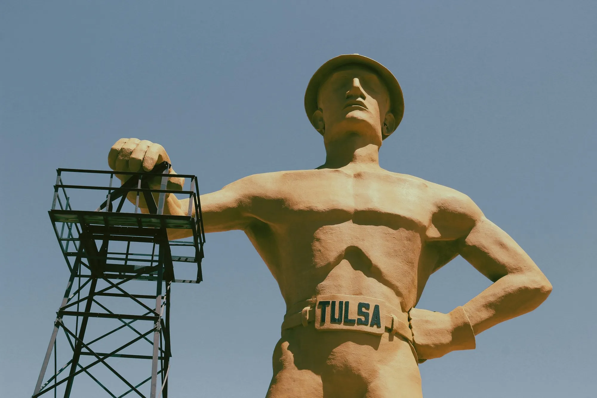 The Golden Driller statue leaning on his oil derrick, TULSA on his belt buckle