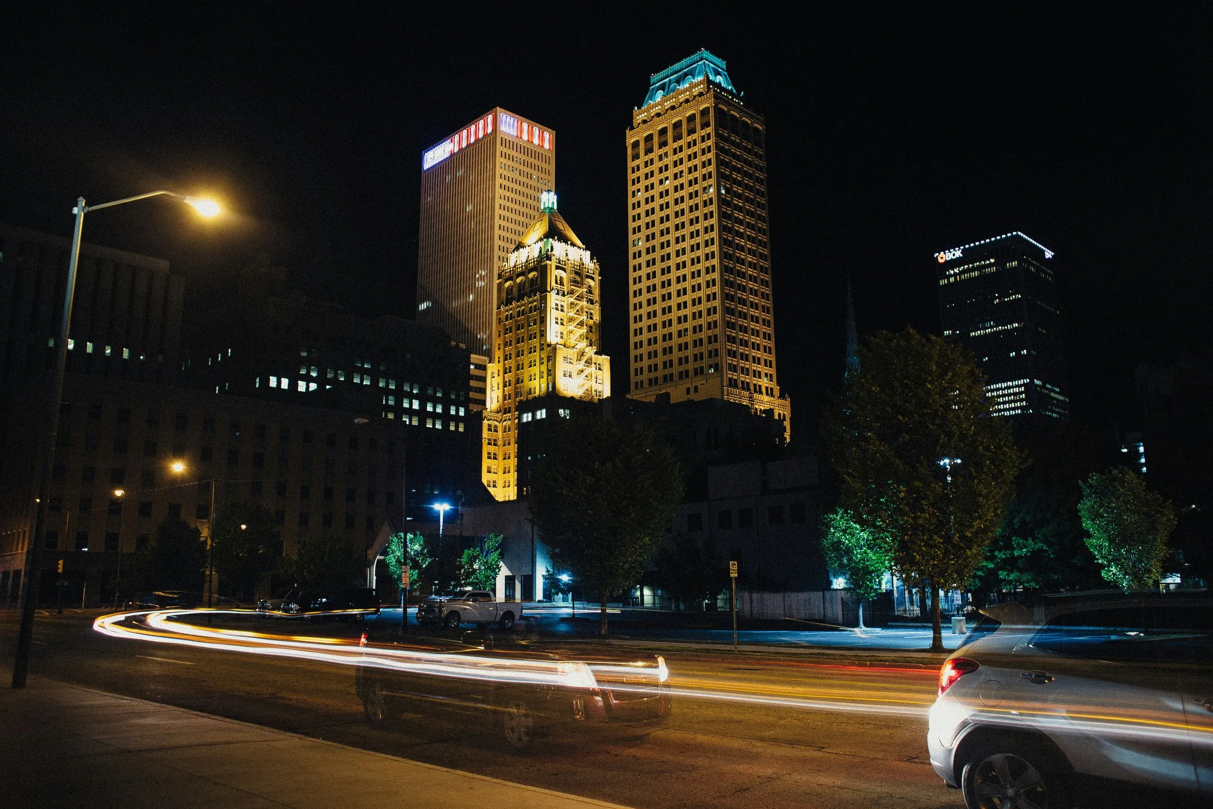 Downtown Tulsa at night, with the lit-up Philtower and car light trails